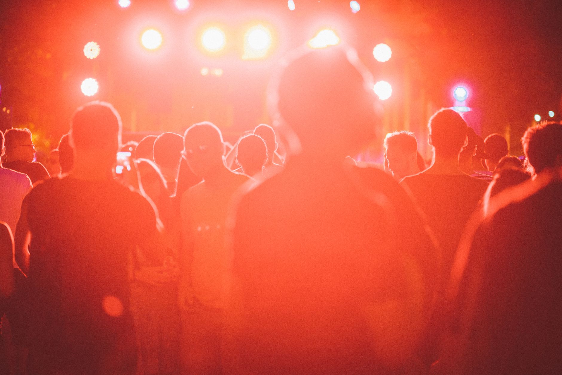 Feiernde Menge im Gegenlicht der Bühnenscheinwerfer bei einem Open-Air-Konzert